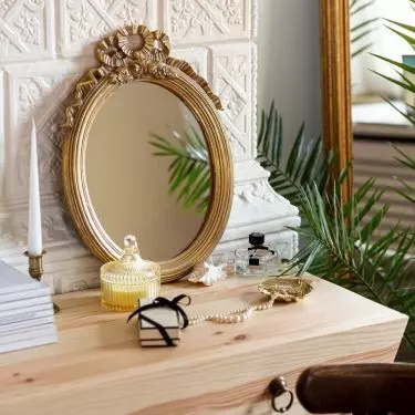 You can combine a modern wooden dressing table with a vintage mirror in an ornate frame