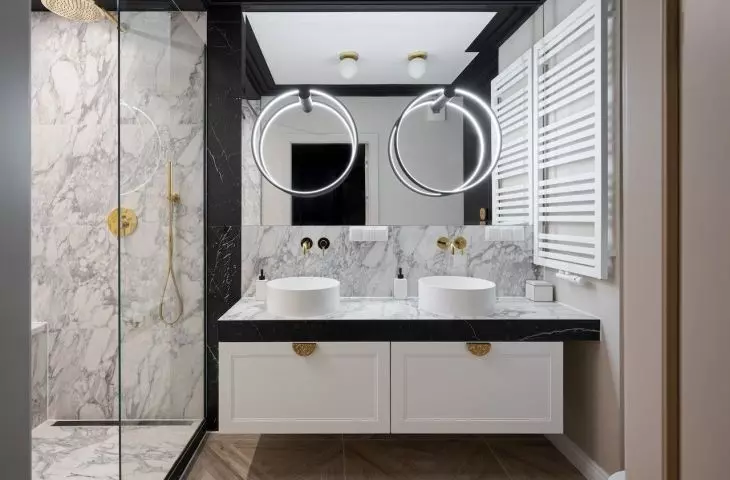 The circular lighting follows the shape of countertop washbasins
