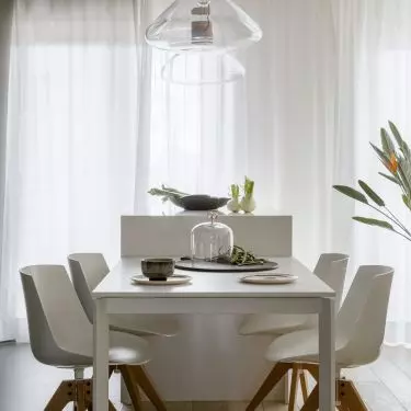 Lamps with wooden details hang in the living area