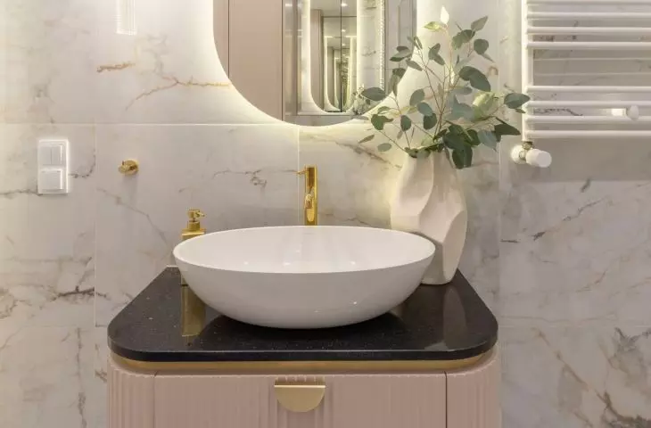 The cabinetry in the bathroom is a shade of soft pink