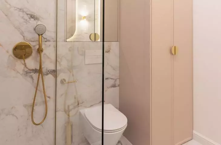 The glass panel that is part of the open shower also separates the toilet from the rest of the room