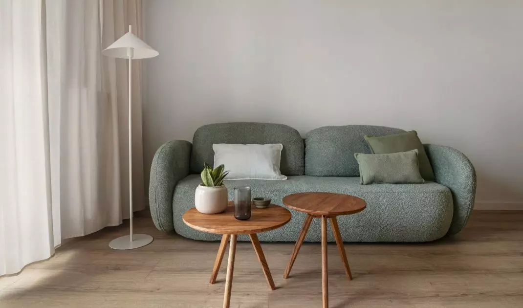 Centralnym elementem strefy wypoczynkowej jest zielona sofa