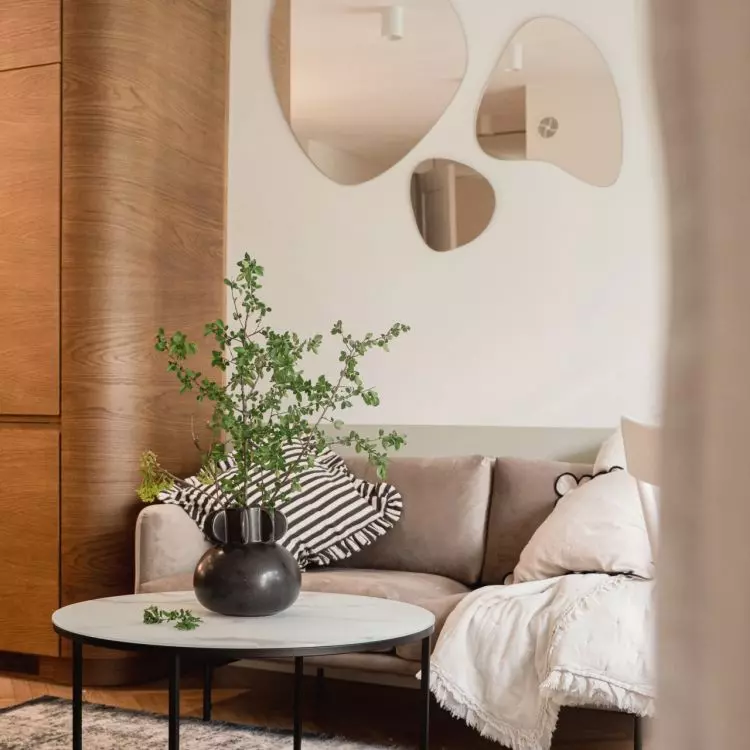 Above the sofa hangs a decoration of mirrors with an organic shape