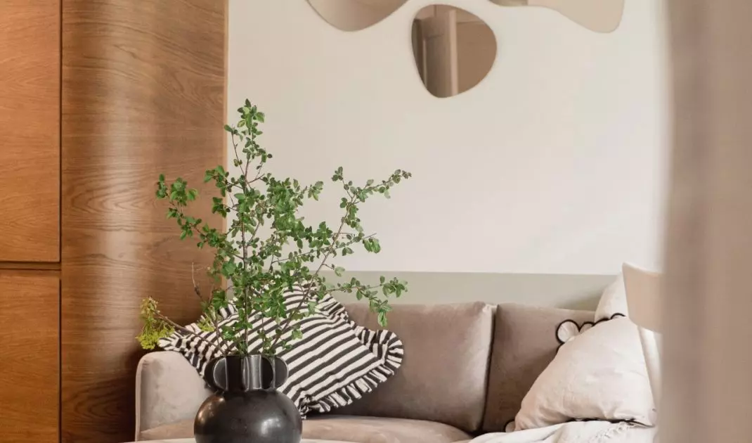 Above the sofa hangs a decoration of mirrors with an organic shape