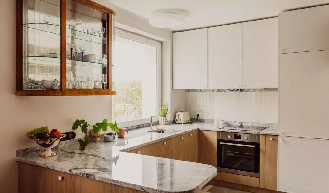 The kitchen is a combination of white, wood and marble