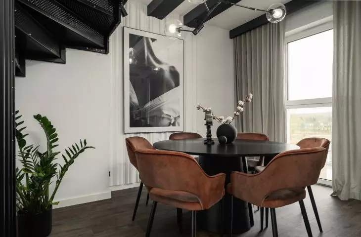 The heart of the dining room is a round black table with a matte finish