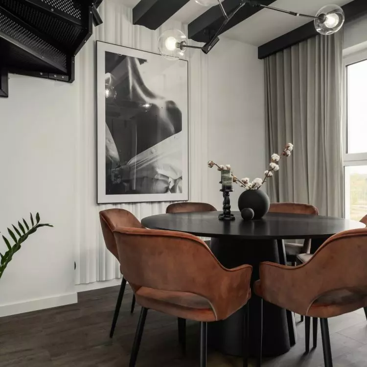 The heart of the dining room is a round black table with a matte finish