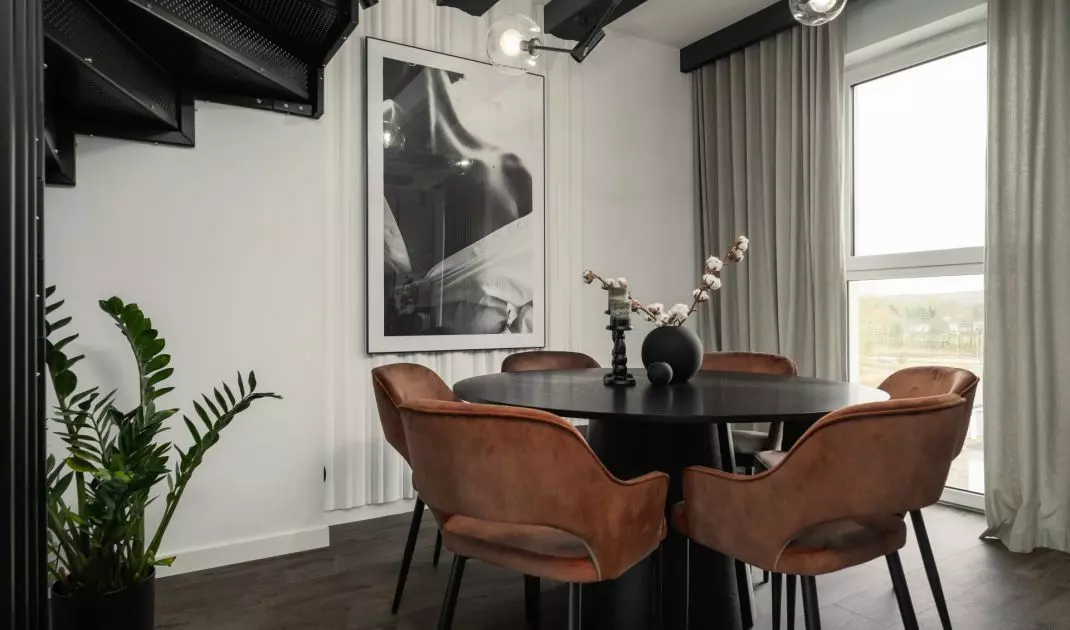 The heart of the dining room is a round black table with a matte finish