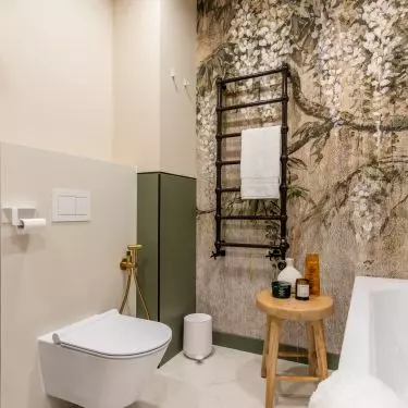 Decorative black radiator hangs on wall with wallpaper