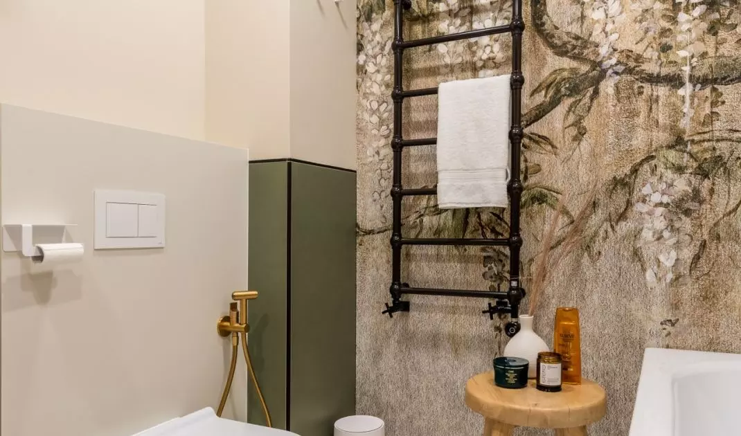 Decorative black radiator hangs on wall with wallpaper