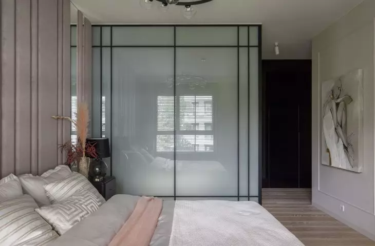 The bedroom is connected to the bathroom arranged in a glass cubicle