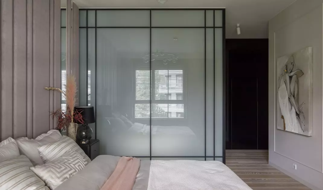 The bedroom is connected to the bathroom arranged in a glass cubicle