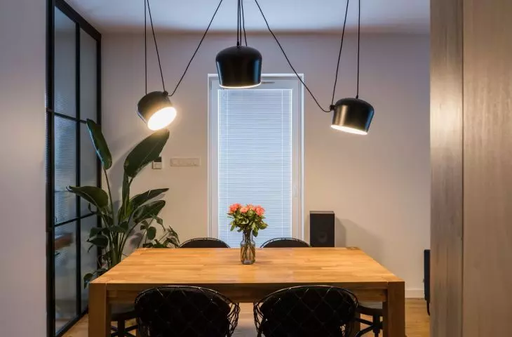 Above the dining room table hangs an interesting composition of black lamps