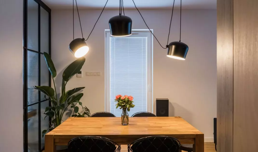 Nad stołem w jadalni zawisła ciekawa kompozycja z czarnych lamp