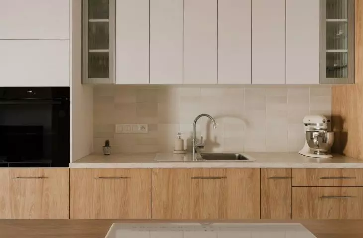 The kitchen cabinetry consists of cabinets with white and wooden fronts and a marble countertop