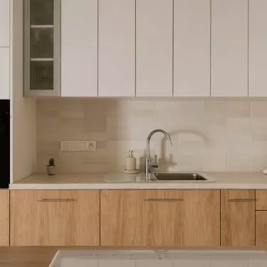 The kitchen cabinetry consists of cabinets with white and wooden fronts and a marble countertop