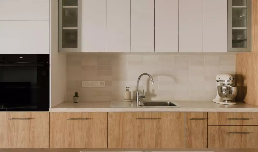 The kitchen cabinetry consists of cabinets with white and wooden fronts and a marble countertop