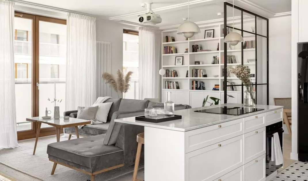 A glass wall separates the kitchen from the living room 
