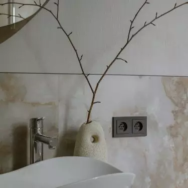 The beige arrangement is complemented by black accessories