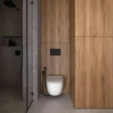 The shower area has been tiled with a terrazzo motif