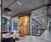 The entirety of Danzig's Montownia Lofts & Experience is kept in gray. Overhead, one can see Heradesign acoustic wood wool panels from Knauf Ceiling Solutions adjacent to the ceilings