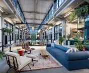 The entirety of Danzig's Montownia Lofts & Experience is kept in gray. Overhead, one can see Heradesign acoustic wood wool panels from Knauf Ceiling Solutions adjacent to the ceilings