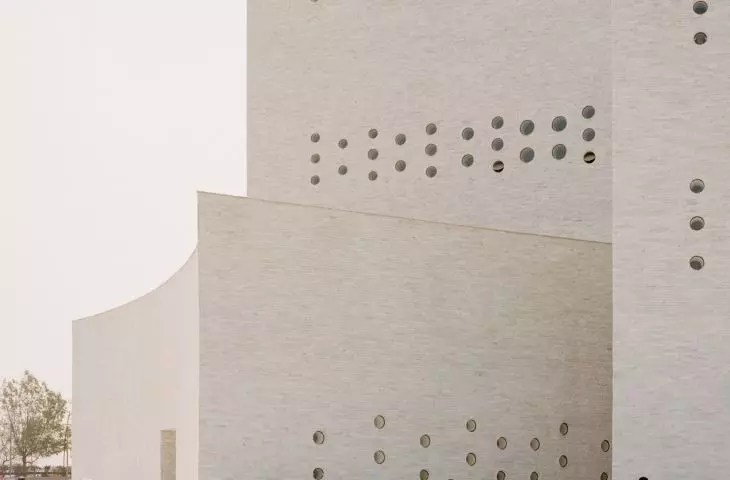 Auditorium at the Jain monastery of Shrimad Rajchandra Ashram in Dharampur, Gujarat - small circular holes, resembling perforations, allow natural light to flow into the interior