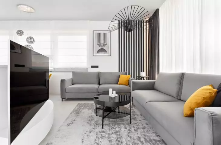 Interior of an apartment in the Baildomb estate in Katowice - living room with gray sofas and yellow pillows