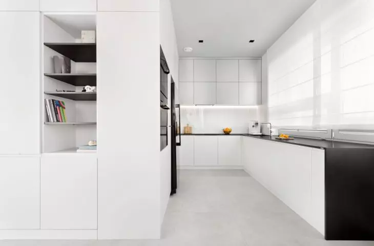 Interior of an apartment in the Baildomb housing estate in Katowice - kitchen with black and white handleless cabinets
