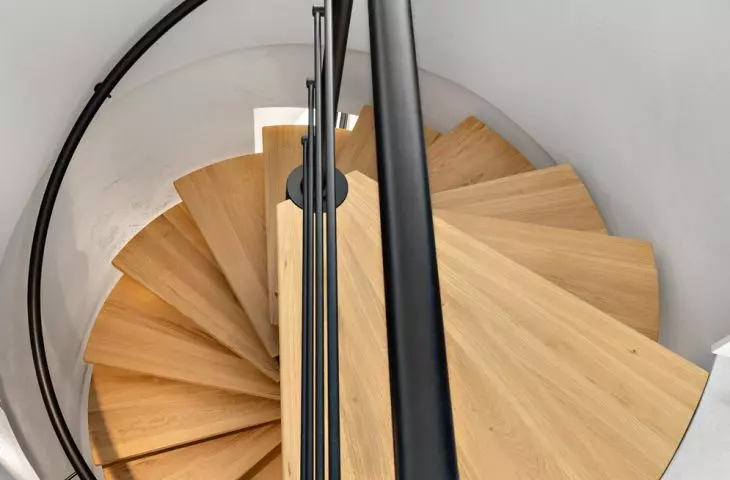 Interior of an apartment at the Baildomb estate in Katowice - a circular wooden staircase connects the two floors