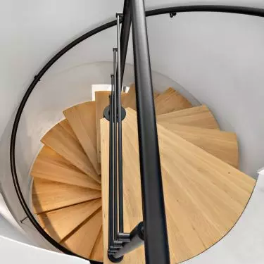 Interior of an apartment at the Baildomb estate in Katowice - a circular wooden staircase connects the two floors
