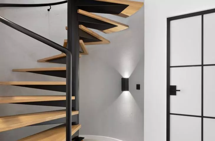 Interior of an apartment at the Baildomb estate in Katowice - a circular wooden staircase connects the two floors