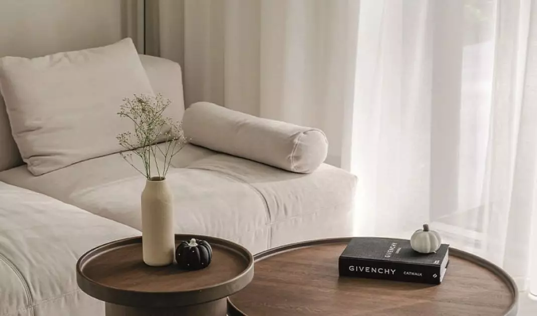 Two wooden coffee tables with cylindrical forms were placed in front of the sofa