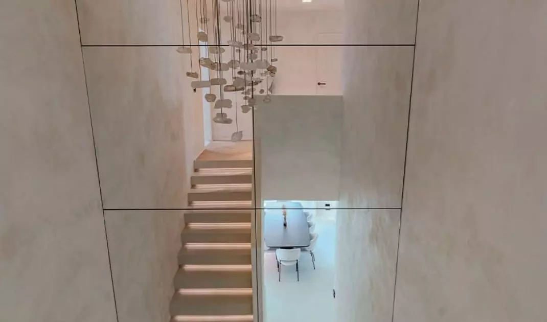 Large mirrors strikingly reflect the raw nuggets of rock crystal forming an impressive chandelier