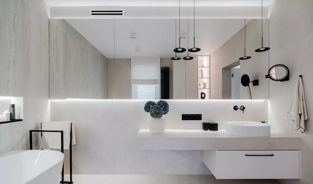 In the bathroom near the bedroom, the architect used a freestanding bathtub and an edgy washbasin