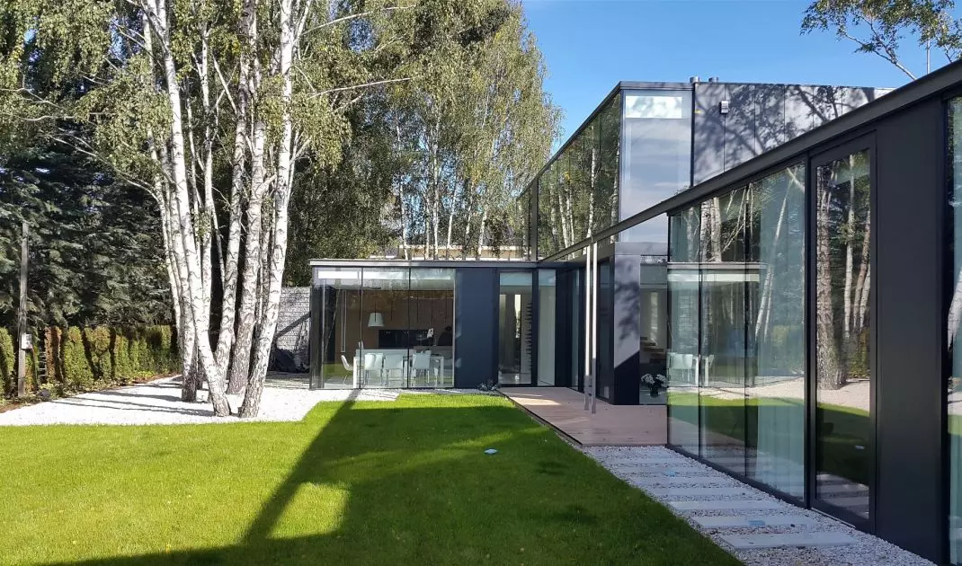 From the garden, the structure resembles a glass pavilion