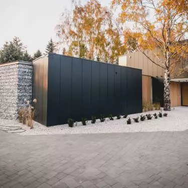 Dark matte facades were juxtaposed with wooden accents and large glazed areas