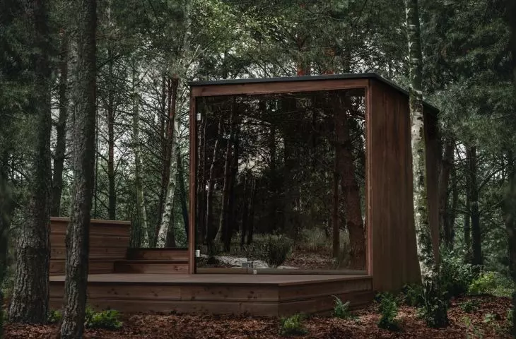 The simple, geometric body of the sauna is equipped with extensive mirrored glazing