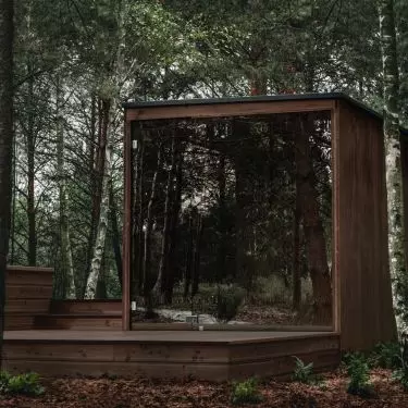 The simple, geometric body of the sauna is equipped with extensive mirrored glazing