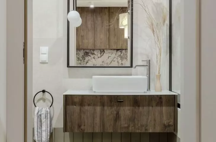Rectangular tiles in a shade of sage green cover both the walls and the floor