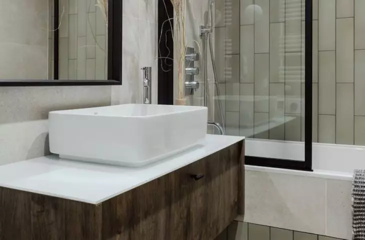 In a small bathroom, the architect used a bathtub screen