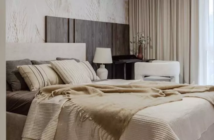 The wall behind the bed is decorated with wallpaper that combines natural motifs with the rawness of concrete