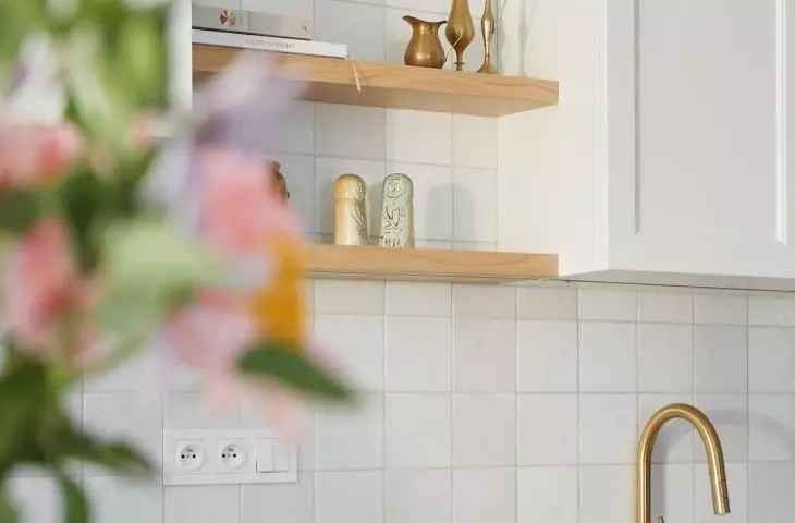 The kitchen is dominated by shades of white and gold