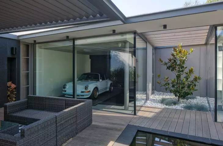 A classic car is exposed in the glass garage