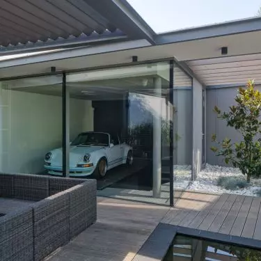 A classic car is exposed in the glass garage