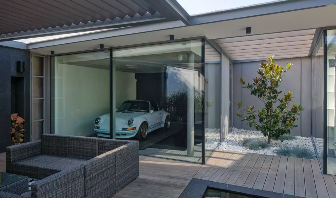 A classic car is exposed in the glass garage