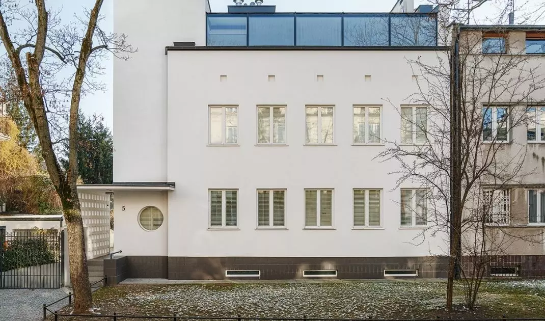Od strony ulicy Lisa Kuli zaprojektowano nowoczesne poddasze w aluminiowo-szklanym systemie, które dodało bryle lekkości i elegancji