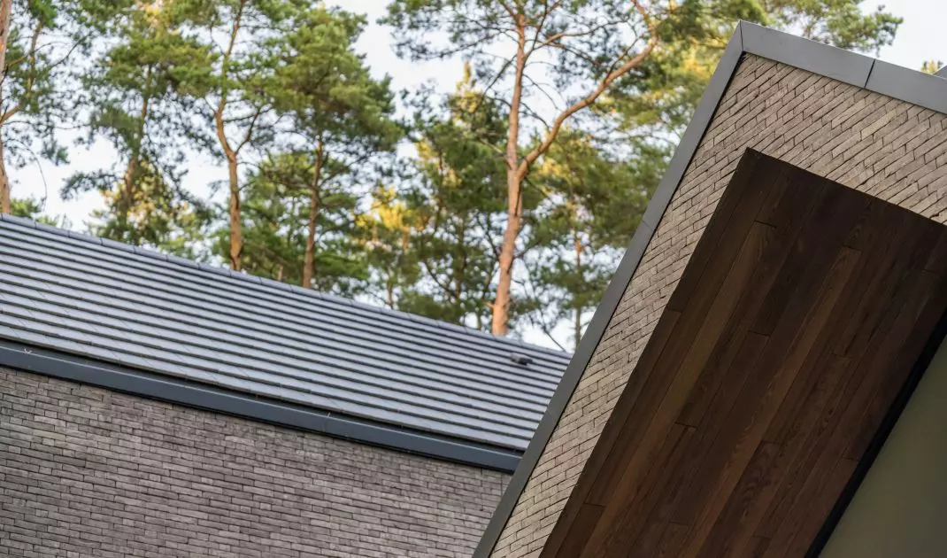 Dwuspadowe dachy wykończono płaską dachówką ceramiczną