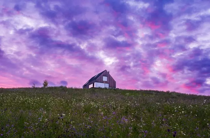 The cottage is placed on a plot with a sloping terrain