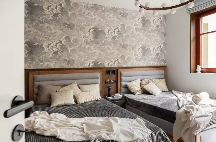 Striking wallpaper on the wall behind the bed adds dynamism to the arrangement